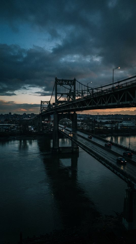 Cinematic film still of bridge over a river, wide shot with open space at the top for text, moody dark tones, dramatic lighting, 9:16 aspect ratio