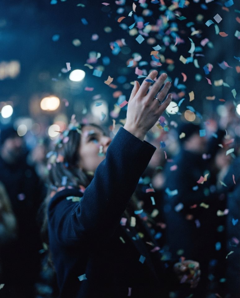Cinematic film still of colorful confetti falling, close-up detail with shallow depth of field, cool blue tones, quiet atmosphere, 4:5 aspect ratio