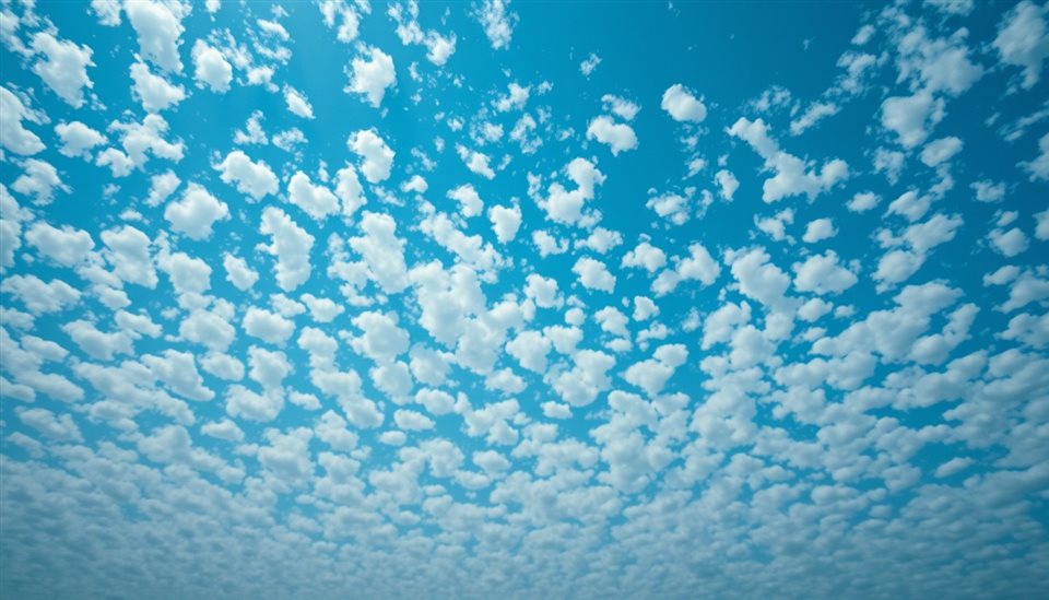 Photorealistic photo of Pattern of small, fluffy white clouds scattered across a bright blue sky like flocks of sheep, wide shot with open space at the top for text, moody dark tones, dramatic lighting, 16:9 aspect ratio