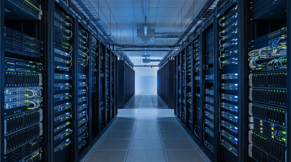 データセンターのサーバーラックの列、写実的な写真、すっきりとシンプルな構図で中央に配置された被写体、クールな青み掛かったトーン、静寂な雰囲気、16:9のアスペクト比