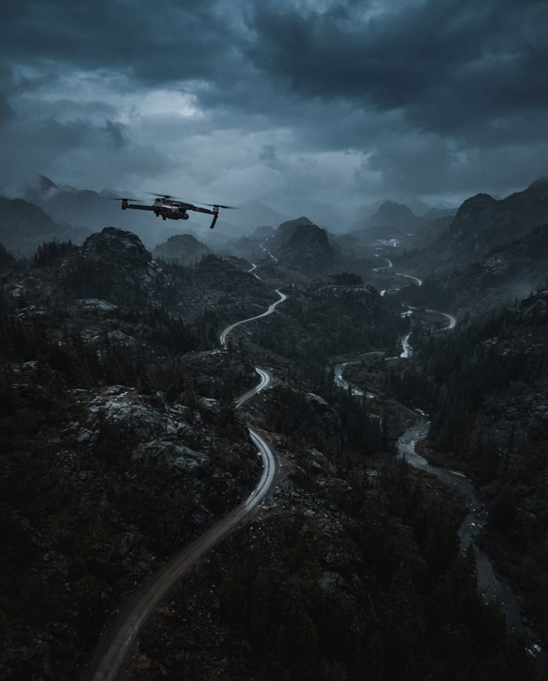Cinematic film still of a drone flying over a landscape, high-angle view from above, moody dark tones, dramatic lighting, 4:5 aspect ratio