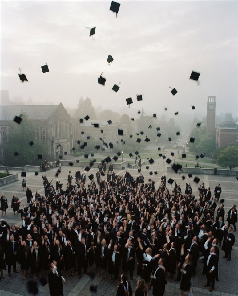 Cinematic film still of graduation caps tossed into the sky, high-angle view from above, misty morning haze, dreamy, 4:5 aspect ratio