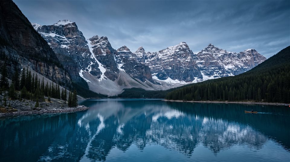Cinematic film still of ultra detailed majestic mountain lake landscape, wide shot with open space at the top for text, cool blue tones, quiet atmosphere, 16:9 aspect ratio