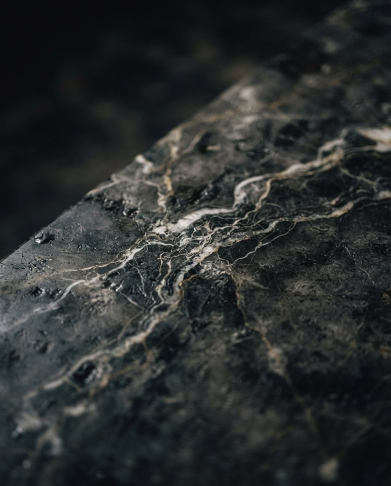Cinematic film still of marble texture, close-up detail with shallow depth of field, moody dark tones, dramatic lighting, 4:5 aspect ratio