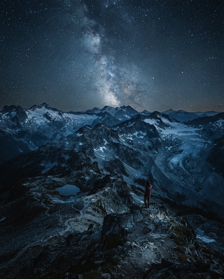 Cinematic film still of milky way over mountains, high-angle view from above, cool blue tones, quiet atmosphere, 4:5 aspect ratio
