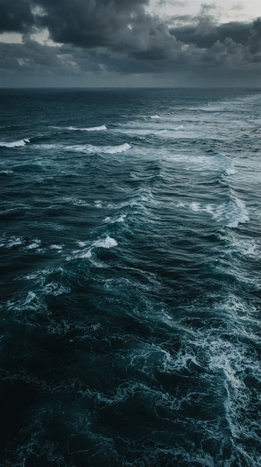 Cinematic film still of calm turquoise ocean with gentle waves, high-angle view from above, moody dark tones, dramatic lighting, 9:16 aspect ratio