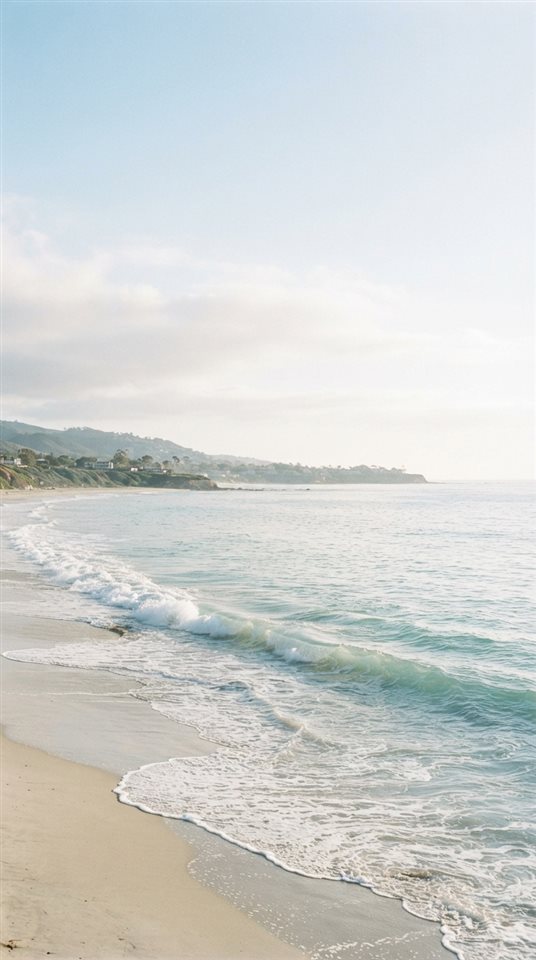 Cinematic film still of ocean waves, wide shot with open space at the top for text, soft pastel colors, bright and cozy, 9:16 aspect ratio