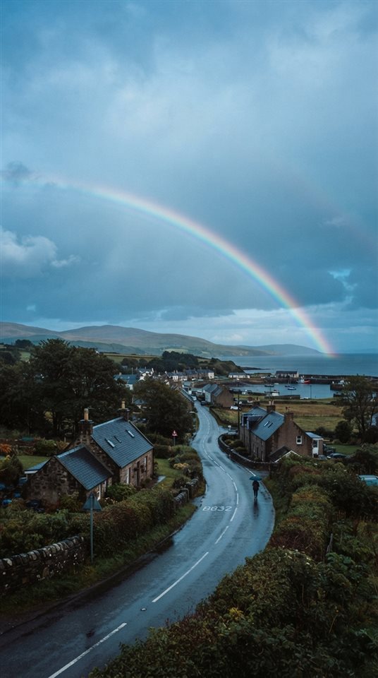 Cinematic film still of rainbow after the rain, wide shot with open space at the top for text, cool blue tones, quiet atmosphere, 9:16 aspect ratio