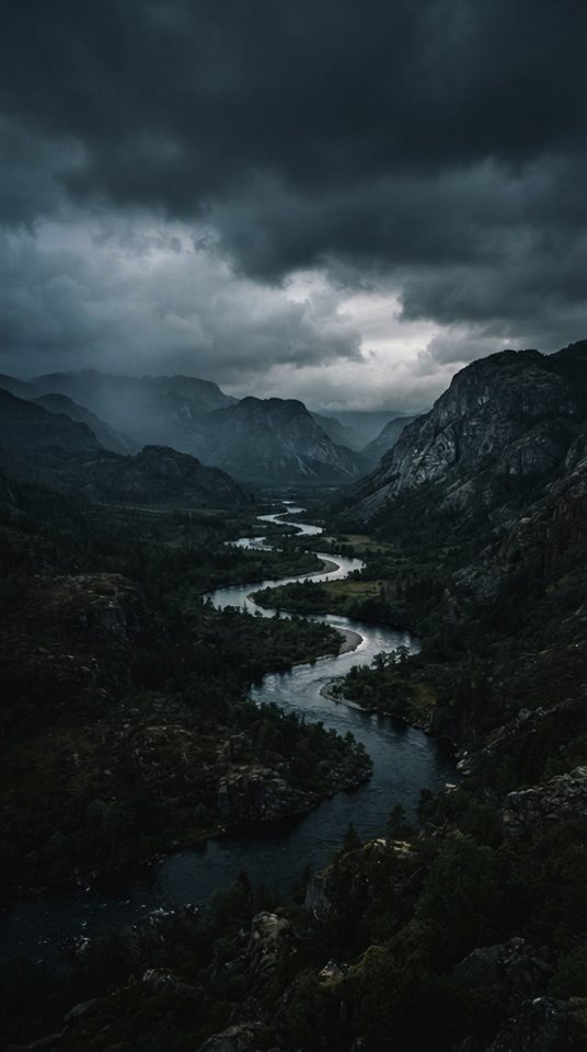 Cinematic film still of winding river through a valley, wide shot with open space at the top for text, moody dark tones, dramatic lighting, 9:16 aspect ratio