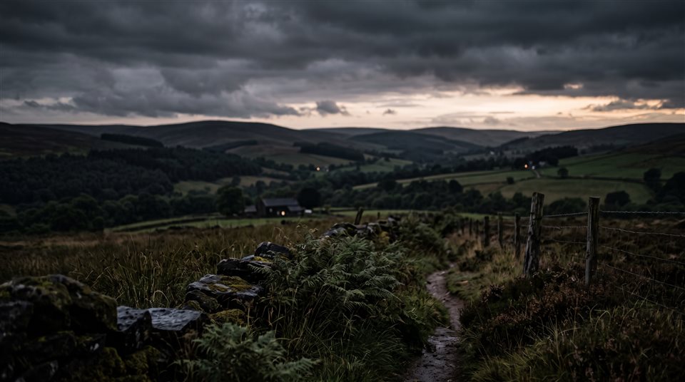 Photorealistic photo of peaceful countryside scenery with rolling hills, close-up detail with shallow depth of field, moody dark tones, dramatic lighting, 16:9 aspect ratio