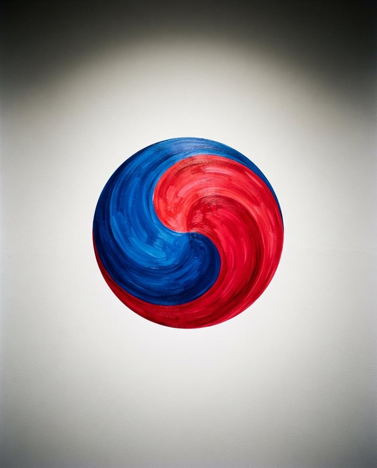Cinematic film still of an abstract red and blue taegeuk swirl design on a clean background, centered subject with a simple uncluttered composition, vivid colors, high contrast, energetic, 4:5 aspect ratio