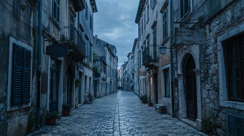 Photorealistic photo of narrow alley with old buildings, wide shot with open space at the top for text, cool blue tones, quiet atmosphere, 16:9 aspect ratio