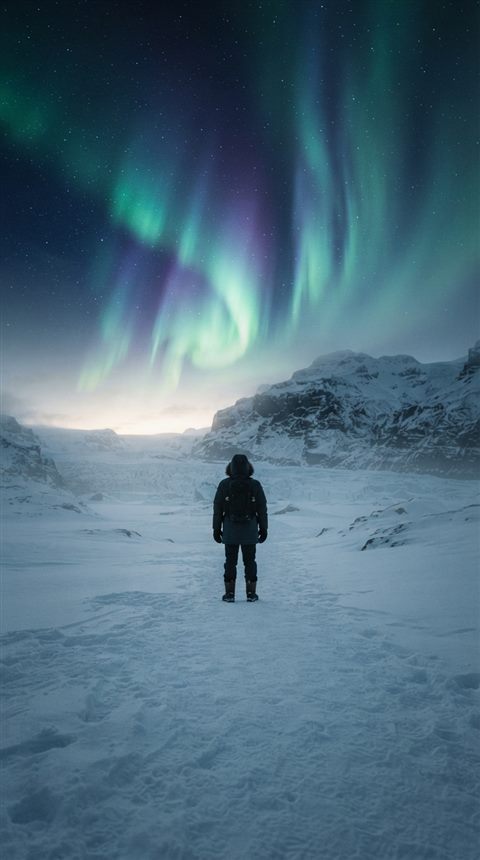 Cinematic film still of aurora borealis over a snowy landscape, centered subject with a simple uncluttered composition, misty morning haze, dreamy, 9:16 aspect ratio