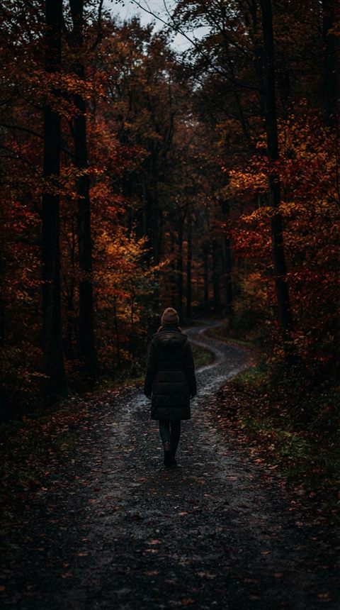 Cinematic film still of autumn trees with red and orange leaves, centered subject with a simple uncluttered composition, moody dark tones, dramatic lighting, 9:16 aspect ratio