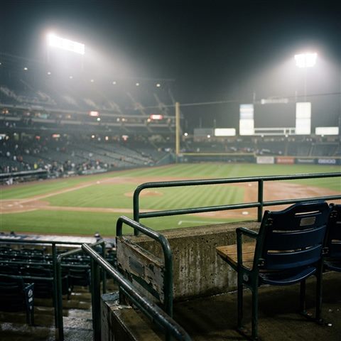 Photorealistic photo of a baseball stadium at night, close-up detail with shallow depth of field, misty morning haze, dreamy, 1:1 aspect ratio