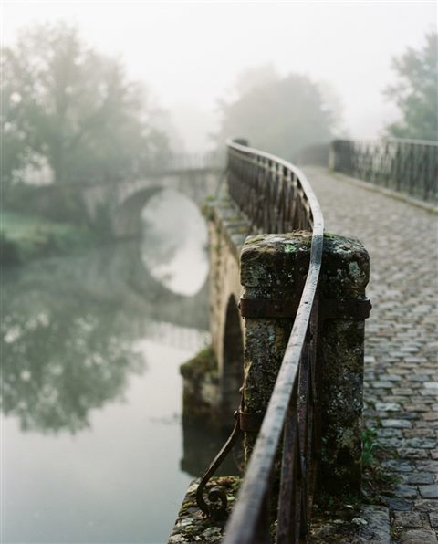 Cinematic film still of bridge over a river, close-up detail with shallow depth of field, misty morning haze, dreamy, 4:5 aspect ratio