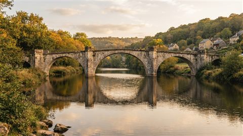 Photorealistic photo of bridge over a river, centered subject with a simple uncluttered composition, warm golden light, calm mood, 16:9 aspect ratio