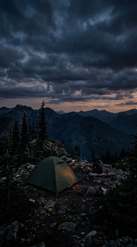 Cinematic film still of camping tent, wide shot with open space at the top for text, moody dark tones, dramatic lighting, 9:16 aspect ratio