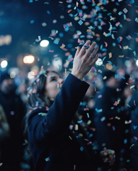 Cinematic film still of colorful confetti falling, close-up detail with shallow depth of field, cool blue tones, quiet atmosphere, 4:5 aspect ratio