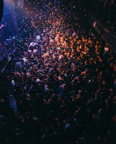 Cinematic film still of colorful confetti falling, high-angle view from above, moody dark tones, dramatic lighting, 4:5 aspect ratio