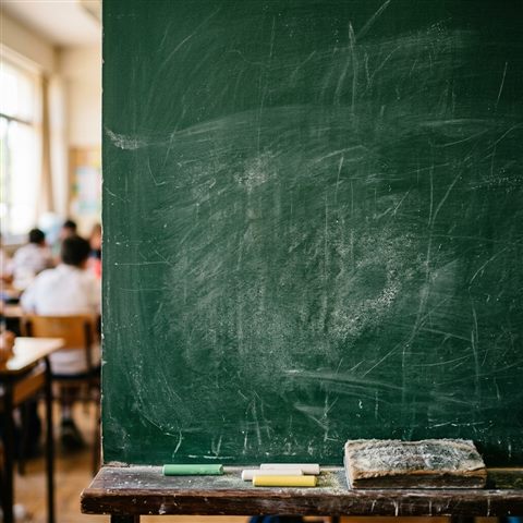 Photorealistic photo of a blank green chalkboard in a classroom, close-up detail with shallow depth of field, vivid colors, high contrast, energetic, 1:1 aspect ratio
