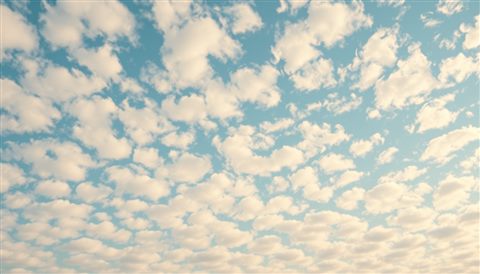 Photorealistic photo of Pattern of small, fluffy white clouds scattered across a bright blue sky like flocks of sheep, close-up detail with shallow depth of field, warm golden light, calm mood, 16:9 aspect ratio