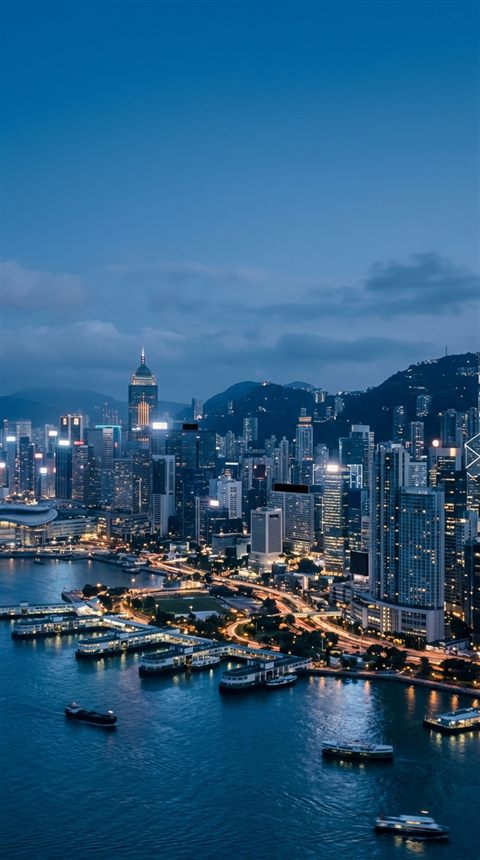 Cinematic film still of modern city skyline, wide shot with open space at the top for text, cool blue tones, quiet atmosphere, 9:16 aspect ratio