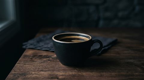 커피 한 잔, 사실적인 사진, 단순하고 깔끔한 구도 가운데 놓인 피사체, 어두운 톤, 극적인 조명, 16:9 비율
