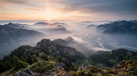 Photorealistic photo of breathtaking wide landscape for a computer desktop, high-angle view from above, misty morning haze, dreamy, 16:9 aspect ratio