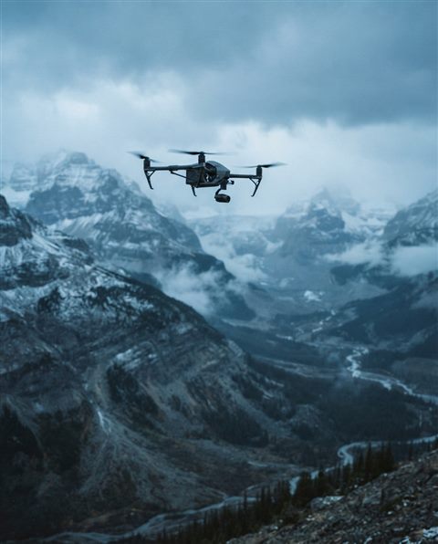Cinematic film still of a drone flying over a landscape, close-up detail with shallow depth of field, cool blue tones, quiet atmosphere, 4:5 aspect ratio