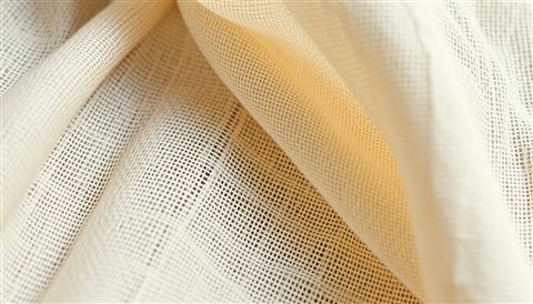 Cinematic film still of A close-up view of soft natural linen fabric showing its fine woven texture and neutral color, close-up detail with shallow depth of field, vivid colors, high contrast, energetic, 16:9 aspect ratio