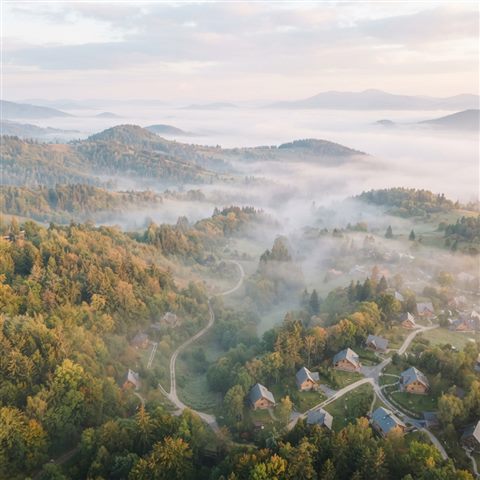 Photorealistic photo of foggy landscape, high-angle view from above, soft pastel colors, bright and cozy, 1:1 aspect ratio