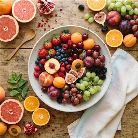 Photorealistic photo of colorful fresh fruits, high-angle view from above, soft pastel colors, bright and cozy, 1:1 aspect ratio