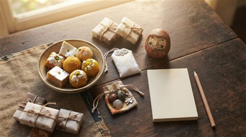 Photorealistic photo of lucky charms and traditional sweets for passing an exam, high-angle view from above, warm golden light, calm mood, 16:9 aspect ratio