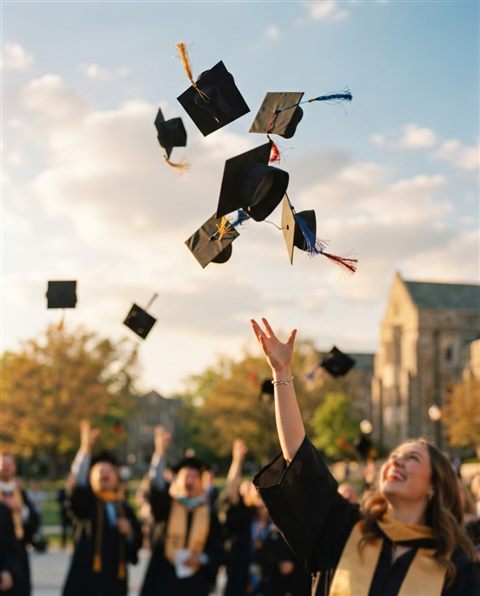 Cinematic film still of graduation caps tossed into the sky, close-up detail with shallow depth of field, warm golden light, calm mood, 4:5 aspect ratio