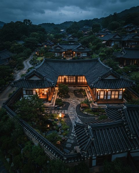 Photorealistic photo of a traditional Korean hanok house with curved tiled roofs and a courtyard, high-angle view from above, moody dark tones, dramatic lighting, 4:5 aspect ratio