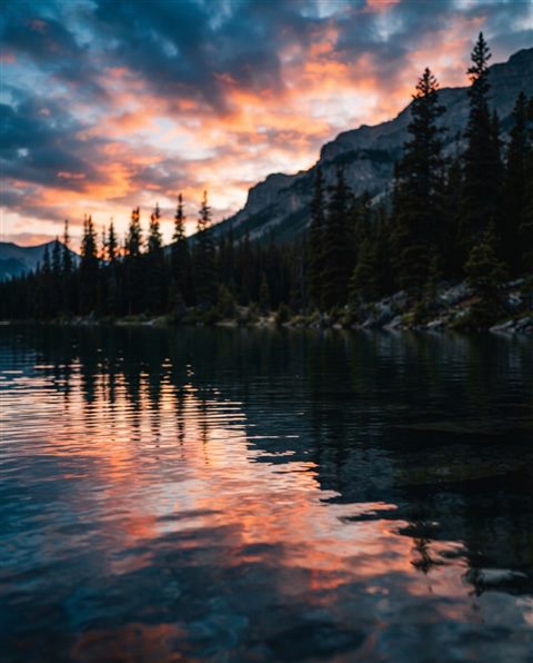 Cinematic film still of calm lake reflecting the sky, close-up detail with shallow depth of field, vivid colors, high contrast, energetic, 4:5 aspect ratio