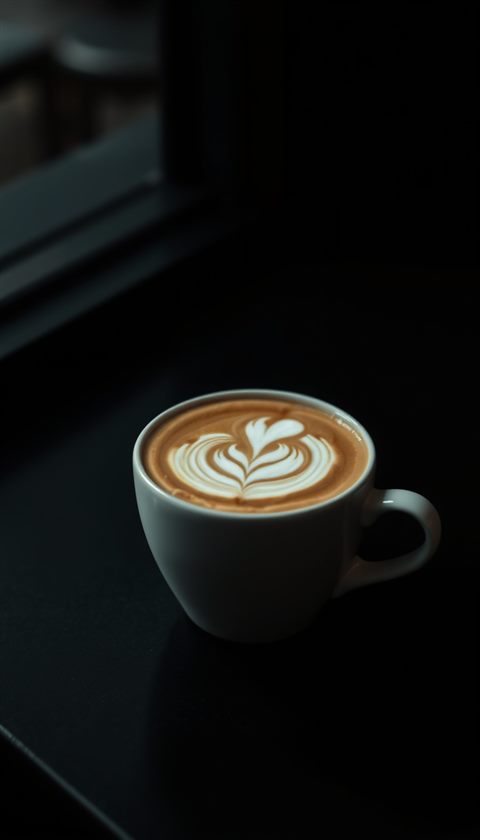 Photorealistic photo of A ceramic cup of hot coffee with a delicate white swan latte art design on top, centered subject with a simple uncluttered composition, moody dark tones, dramatic lighting, 9:16 aspect ratio