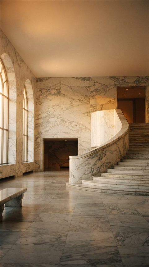 Cinematic film still of marble texture, wide shot with open space at the top for text, warm golden light, calm mood, 9:16 aspect ratio