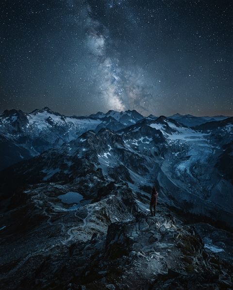 Cinematic film still of milky way over mountains, high-angle view from above, cool blue tones, quiet atmosphere, 4:5 aspect ratio