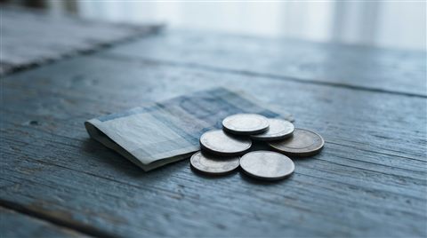 Photorealistic photo of coins and banknotes, centered subject with a simple uncluttered composition, cool blue tones, quiet atmosphere, 16:9 aspect ratio