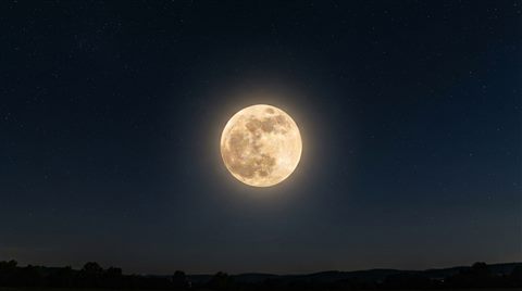Photorealistic photo of full moon in the night sky, centered subject with a simple uncluttered composition, warm golden light, calm mood, 16:9 aspect ratio