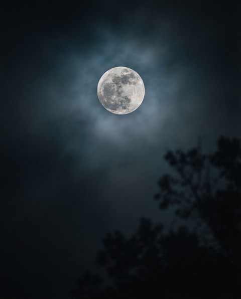 Cinematic film still of full moon in the night sky, close-up detail with shallow depth of field, misty morning haze, dreamy, 4:5 aspect ratio