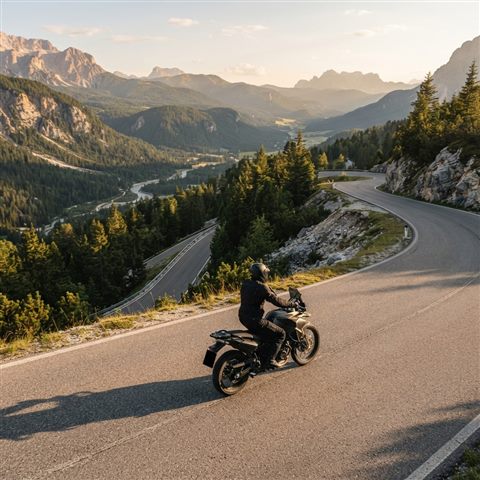 Photorealistic photo of a motorcycle on a mountain road, high-angle view from above, warm golden light, calm mood, 1:1 aspect ratio