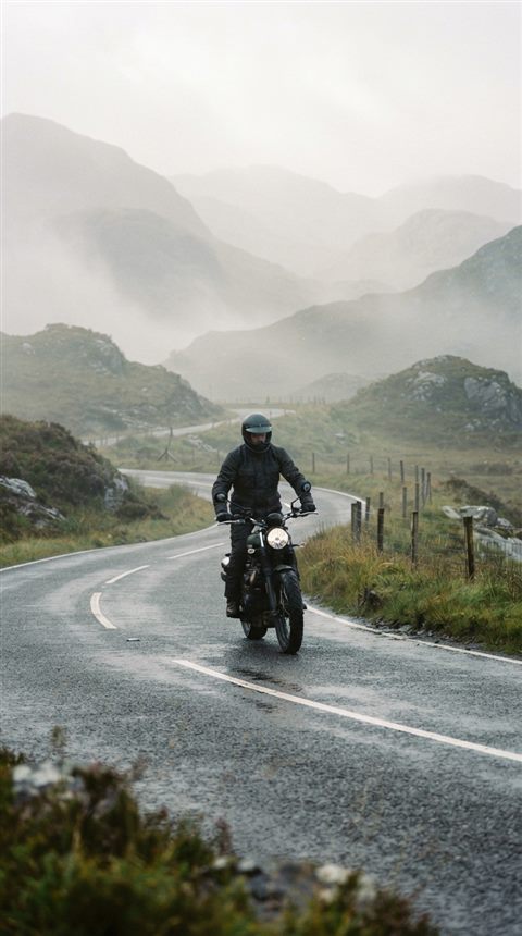 Cinematic film still of a motorcycle on a mountain road, centered subject with a simple uncluttered composition, misty morning haze, dreamy, 9:16 aspect ratio