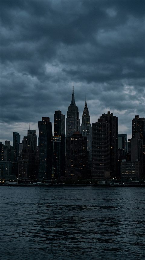 Cinematic film still of the New York City skyline, centered subject with a simple uncluttered composition, moody dark tones, dramatic lighting, 9:16 aspect ratio