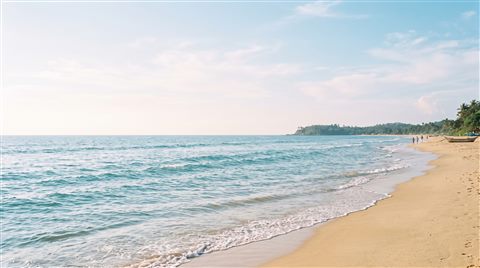 Cinematic film still of calm turquoise ocean with gentle waves, wide shot with open space at the top for text, soft pastel colors, bright and cozy, 16:9 aspect ratio