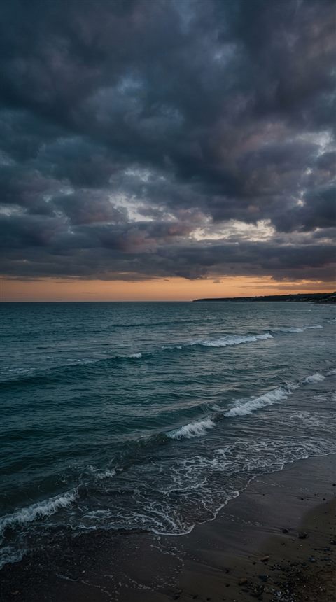 Photorealistic photo of calm turquoise ocean with gentle waves, wide shot with open space at the top for text, moody dark tones, dramatic lighting, 9:16 aspect ratio