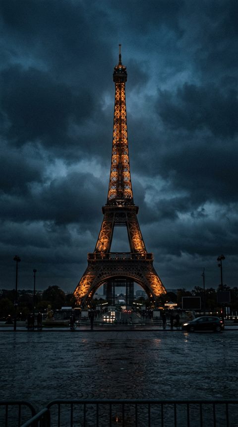 Cinematic film still of the Eiffel Tower in Paris, centered subject with a simple uncluttered composition, moody dark tones, dramatic lighting, 9:16 aspect ratio