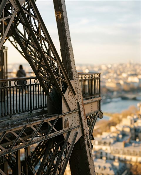 Cinematic film still of the Eiffel Tower in Paris, close-up detail with shallow depth of field, warm golden light, calm mood, 4:5 aspect ratio